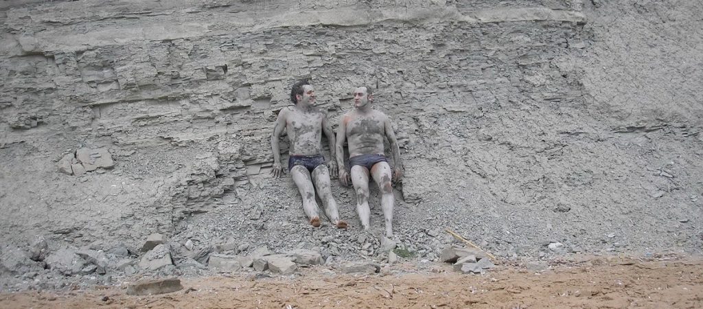 Image of 2 people covered in clay